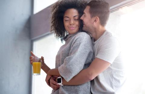 Couple in a relaxed embrace by a window, symbolising safety, connection, and nervous system regulation in intimacy