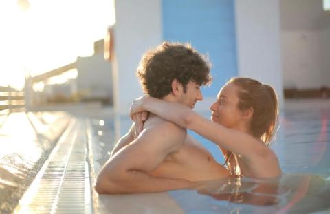 Couple embracing in a rooftop pool, representing relaxation, pleasure and nervous system regulation for better sexual connection